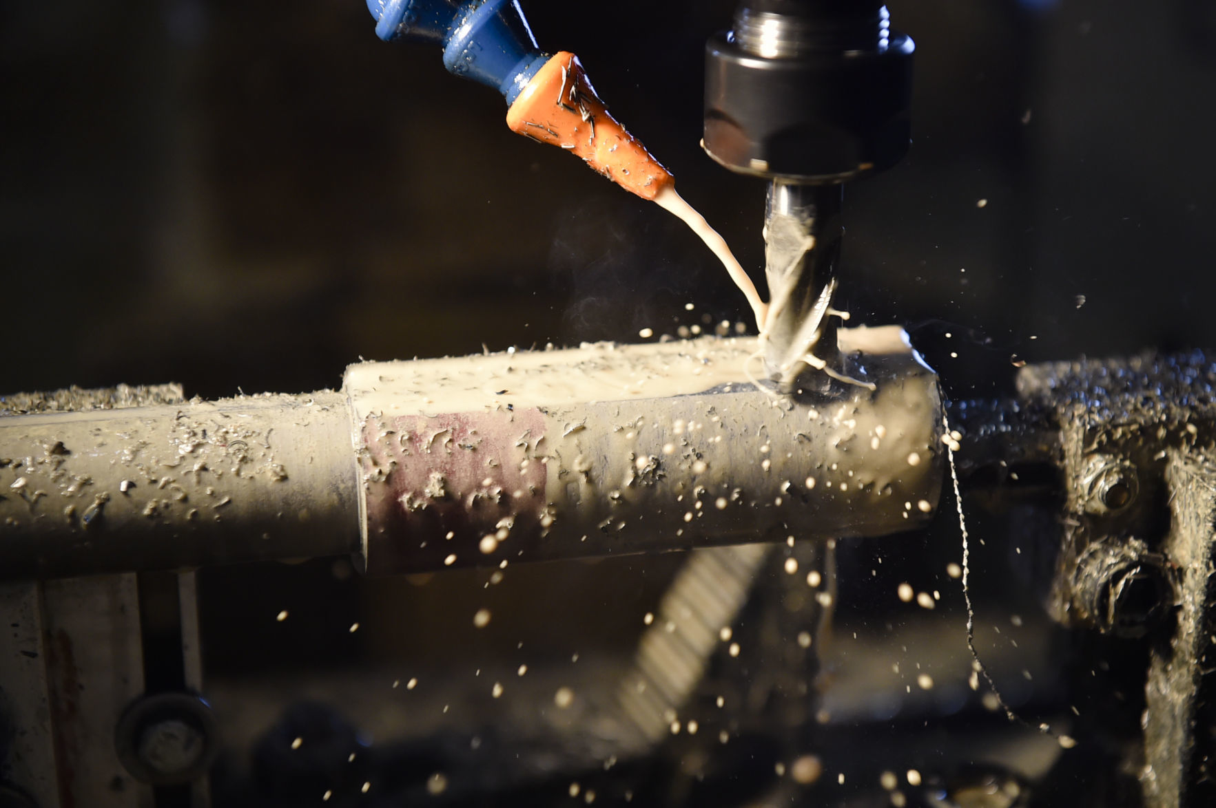 Metal shavings fly off a barrel in the milling process.